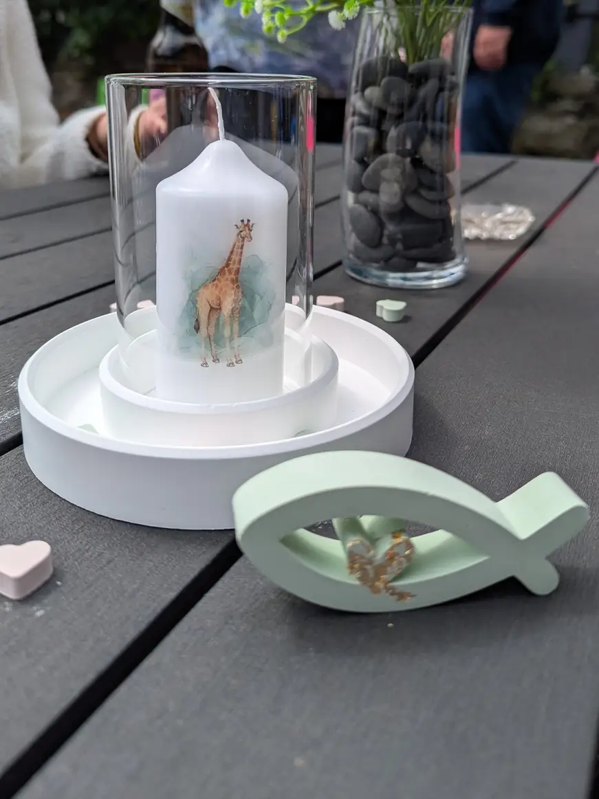 Kerze im Glas und ein grüner Fisch zur Kommunion