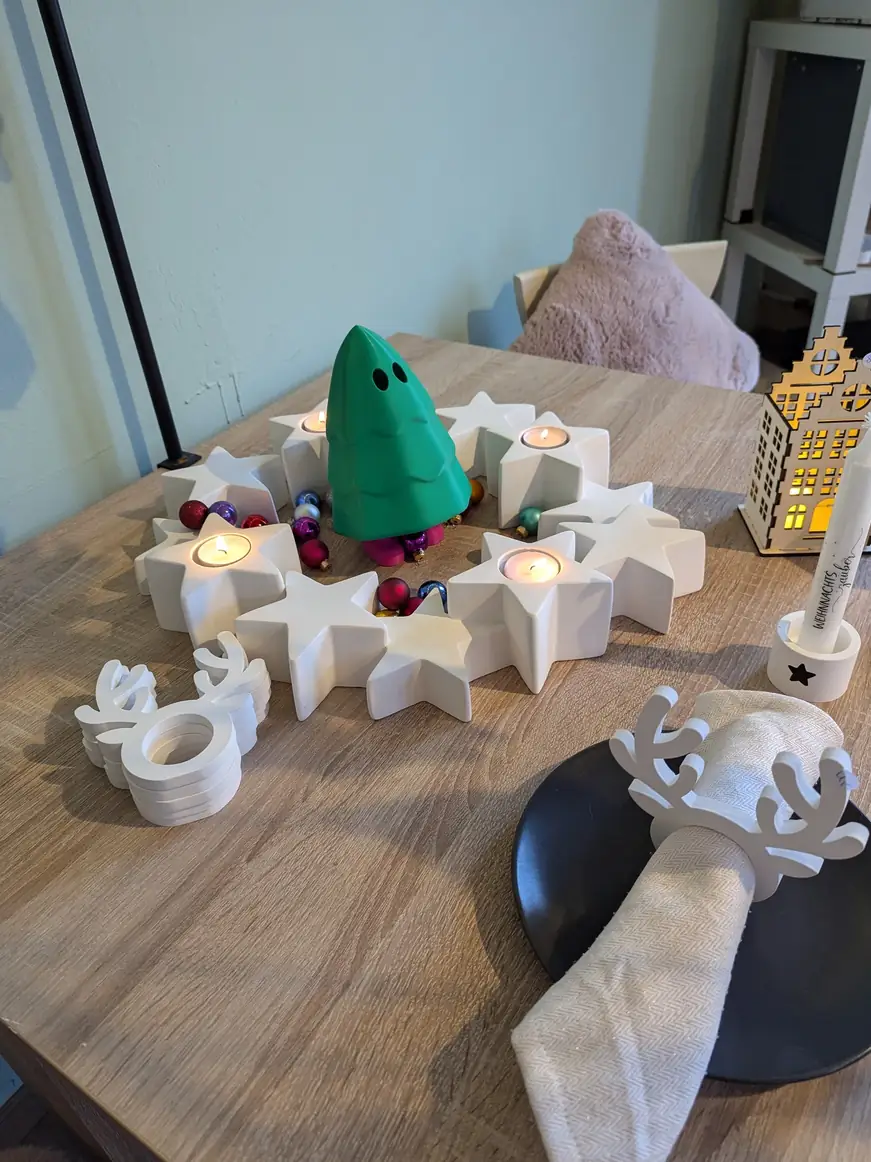 Tisch mit Sternen, Rentier und einem grünen Tannenbaum